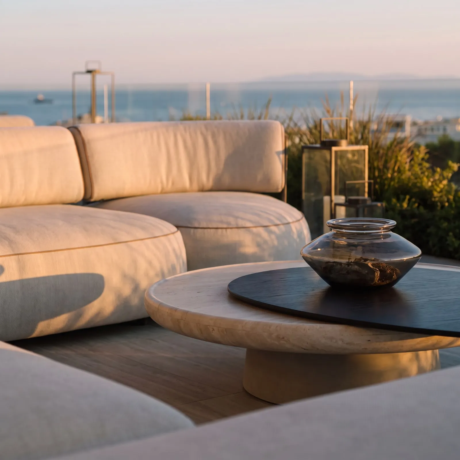 A sculpted table and soft upholstery against the sea.